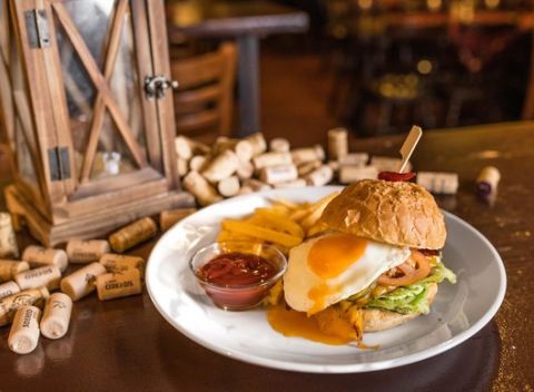 Chrumkavý hovädzí burger s volským okom, slaninou a hranolkami v Českej pivnici.