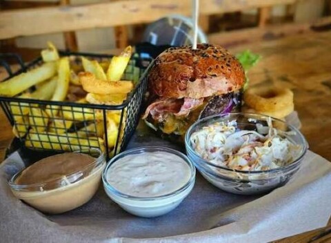 Poctivý hovädzí burger s poriadnou porciou príloh - hranolčeky, coleslaw šalát aj cibuľové krúžky