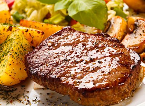 Poriadna porcia chutného mäsa v reštaurácii Malibu. Lahodný hovädzí steak s pečenými zemiakmi či hranolkami, zeleninovou oblohou a vínom. 