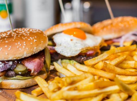 Domáci hovädzí burger v Dileme. Zahryznite sa do šťavnatého burgera s cheddarom, slaninkou a oštiepkom či volským okom a k tomu hranolky.