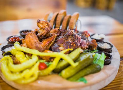 Voňavé marinované rebrá, chrumkavé BBQ krídla, k tomu baranie rohy, uhorky, feferóny a chlieb. Misa špecialít v pivárni Bayerova Sladovňa.